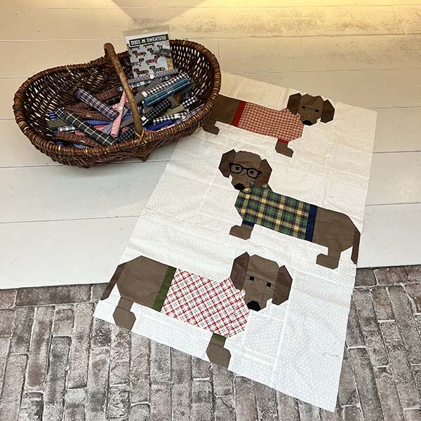 Anneke kocht een tijdje geleden dit leuke 'Dogs in Sweaters' patroon van Elizabeth Hartman in onze winkel. Met leuke ruitjes stofjes uit onze ruitjes mand. En vandaag had ze hem mee voor een randstof en achterkantje. Wat een superleuk quiltje! Het patroon staat in de webshop (klik).